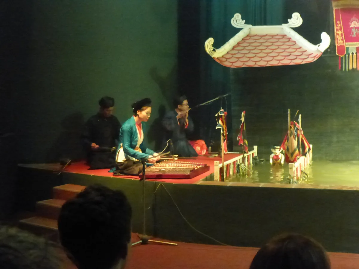 A traditional Vietnamese water puppet performer and lotus-themed puppet stage